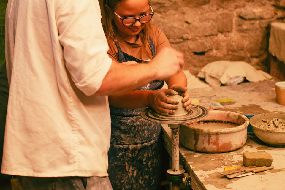Due persone impegnate nella lavorazione artigianale della ceramica