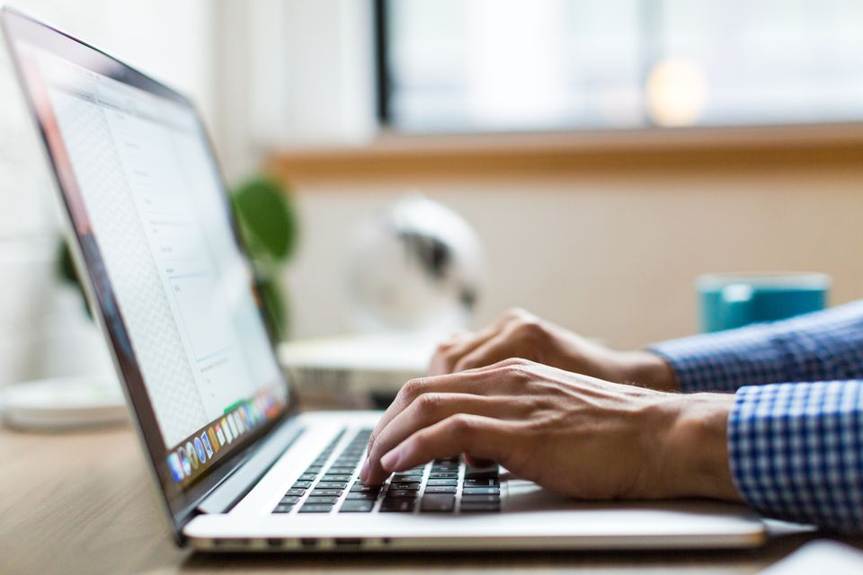 Mani al lavoro sulla tastiera di un computer portatile